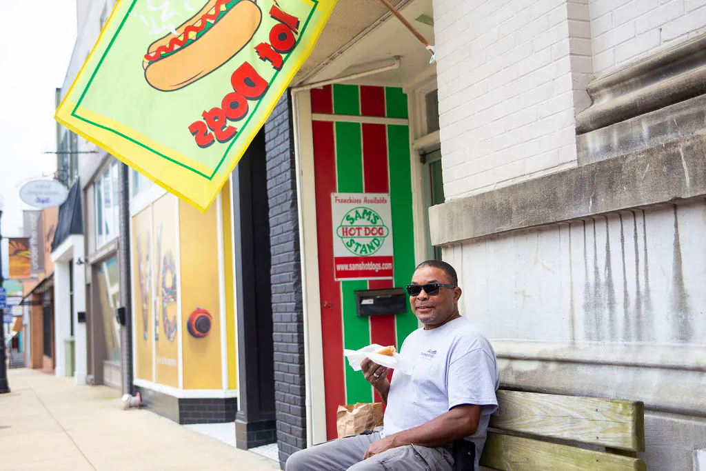 Man sitting outside of Sam's Hot Dog Stand in Downtown Waynesboro, VA