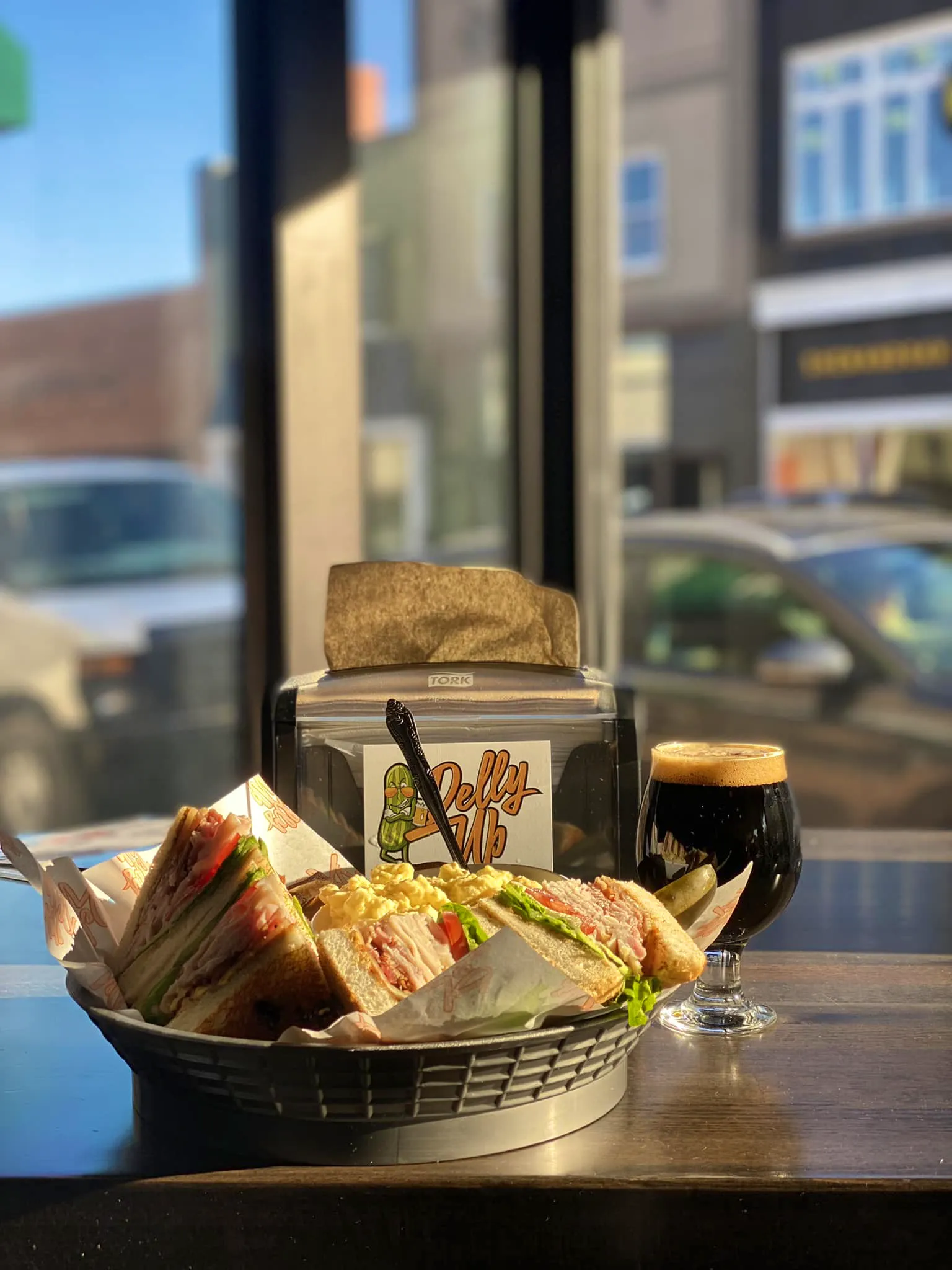 A photo of a club sandwich and a beer