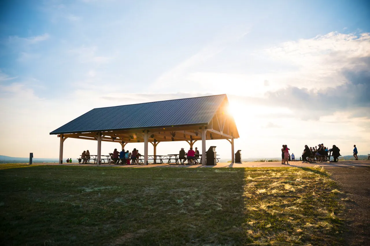 The pavilion at Sunset Park with people setting at picnic tables